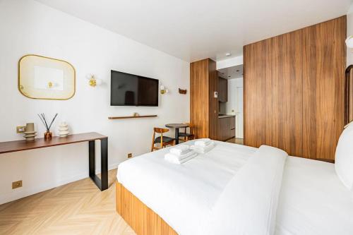 une chambre avec un grand lit blanc et un bureau dans l'établissement 151 Suite luxueuse-Etienne Marcel-Châtelet-Paris 3, à Paris