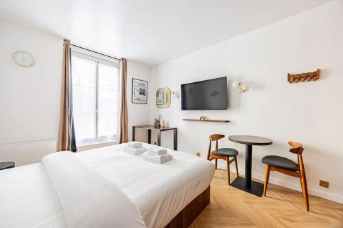 une chambre avec un lit, une table et une télévision dans l'établissement 151 Suite luxueuse-Etienne Marcel-Châtelet-Paris 3, à Paris