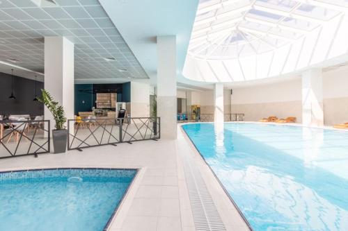 a large swimming pool in a building with a ceiling at 30th Floor-Skyline above a City in Skopje