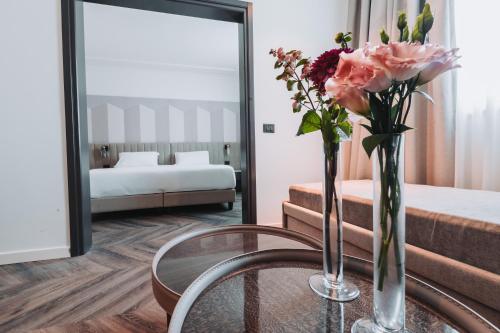 a room with a table with a vase of flowers at Royal Garden Assago Milano in Assago