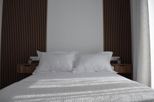 a bedroom with a large bed with white sheets and pillows at Quercus in Pozoblanco