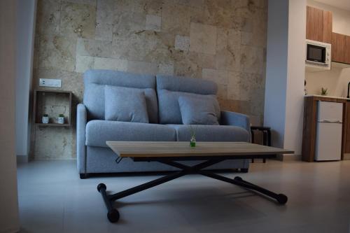 a blue couch in a living room with a coffee table at Quercus in Pozoblanco