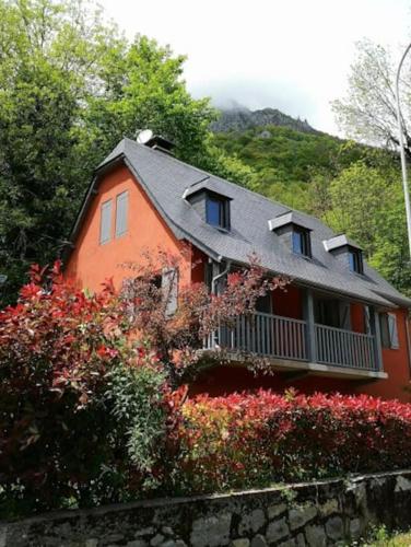 a red house with a balcony on the side of it at ESTRELIAS - maison de vacances - Cauterets centre in Cauterets