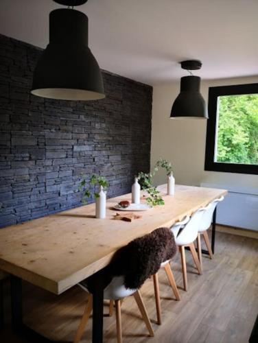 une salle à manger avec une table en bois et un mur en briques dans l'établissement ESTRELIAS - maison de vacances - Cauterets centre, à Cauterets
