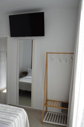 a bedroom with a mirror and a tv on the wall at Quercus in Pozoblanco