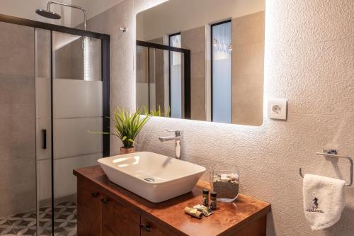 a bathroom with a sink and a large mirror at Beachfront Villa Atalandia with Heated Pool, Gym, BBQ & Office in Goúdhouros