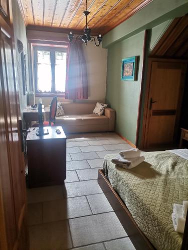 a bedroom with a bed and a window and a couch at Konstantinou & Elenis in Monodendri