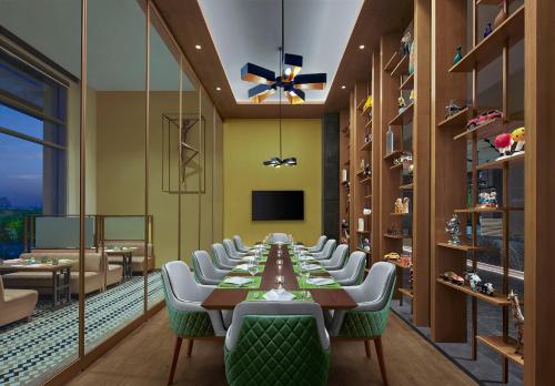 a long dining room with a long table and chairs at Hyatt Place Aurangabad Airport in Aurangabad