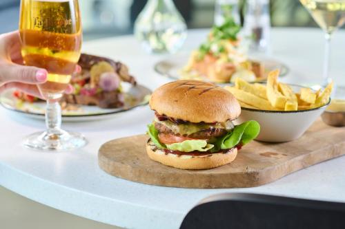 a sandwich and french fries on a table with a glass of beer at Cityden Zuidas in Amstelveen