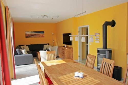 a dining room with a table and a living room at Ferienhaus Meinholdstraße mit eigener Sauna, Kamin, 4 Schlafzimmern ca 500m vom Ostseestrand in Ostseebad Koserow