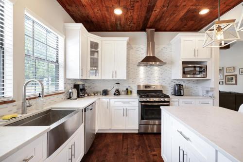 a kitchen with white cabinets and a wooden ceiling at Getaway Near River Walk DT Yard BBQ Pet Games in San Antonio