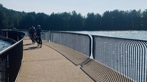 people riding bikes on a bridge over a body of water at Guesthouse De Wissen in Dilsen-Stokkem