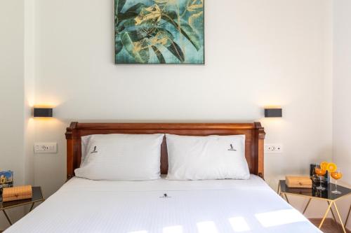 a bedroom with a bed and a painting on the wall at Beachfront Villa Atalandia with Heated Pool, Gym, BBQ & Office in Goúdhouros