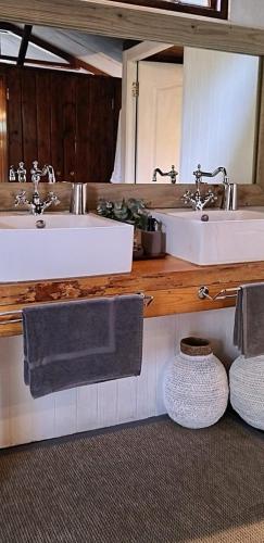 a bathroom with two sinks and a mirror at Barefoot Addo Elephant Lodge in Addo