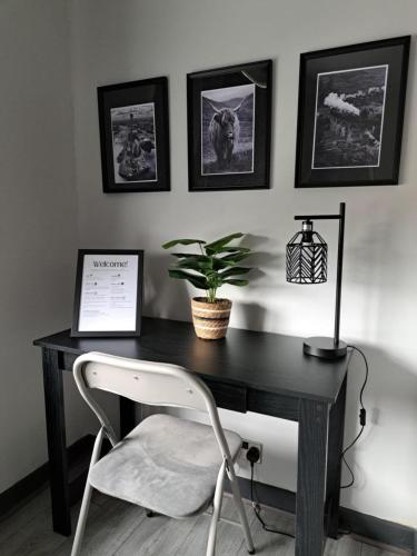 a desk with a chair and a plant on it at Glasgow Apartment close to the airport in Renfrew