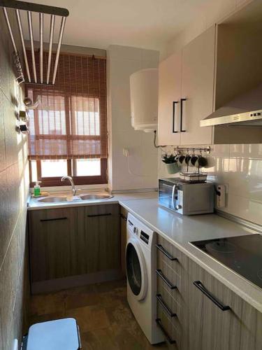 a kitchen with a washer and dryer on the counter at Ático Santa Lucía Terraza y Parking gratuitos in Alcalá de Guadaira