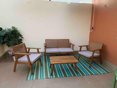three chairs and a table and a bench on a rug at Ático Santa Lucía Terraza y Parking gratuitos in Alcalá de Guadaira