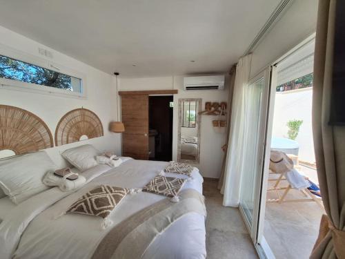 une chambre avec un grand lit et un balcon dans l'établissement L'Amorosa Suite avec terrasse et Jacuzzi extérieur, à Peypin