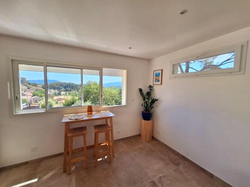 a empty room with a table and two windows at L'Amorosa Suite avec terrasse et Jacuzzi extérieur in Peypin