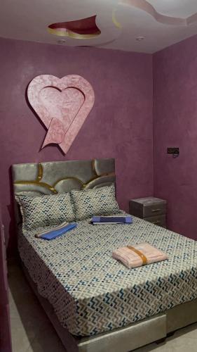 a bedroom with a bed with a heart painted on the wall at Aéroport studio Marrakech in Marrakech