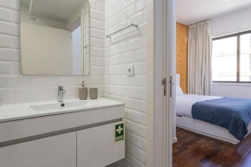 a white bathroom with a sink and a bed at Sena 27 by LovelyStay in Porto