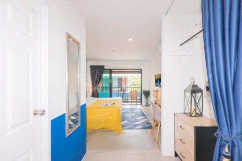 a bedroom with a yellow bed in a room at KRAAM Silhouette Hotel and Cafe Phuket in Chalong 