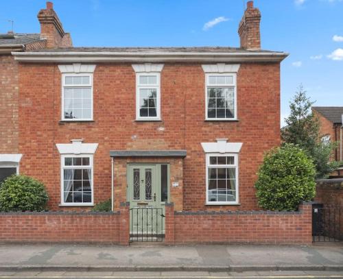 a red brick house with a green door at Picturesque Victorian Cottage in Worcester