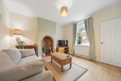 a living room with a couch and a table at Picturesque Victorian Cottage in Worcester