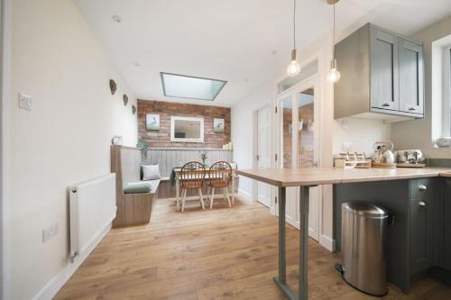 a kitchen with a table and a dining room at Picturesque Victorian Cottage in Worcester