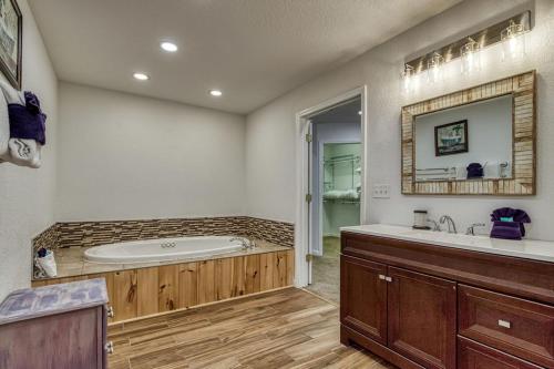 a bathroom with a tub and a sink and a mirror at Bearskin Getaway, Hot Tub, Free Attraction Tickets, WIFI!!! in Sevierville