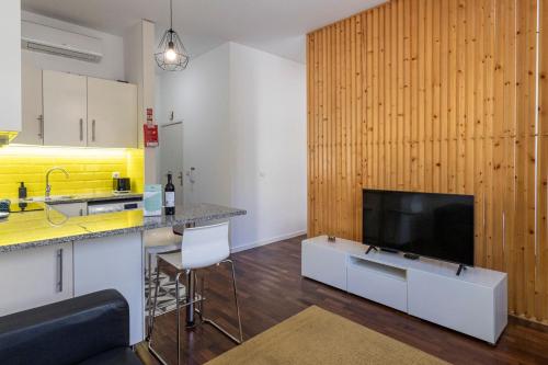 a living room with a kitchen and a television at Sena 27 by LovelyStay in Porto