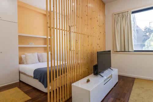 a bedroom with a bed and a tv in it at Sena 27 by LovelyStay in Porto
