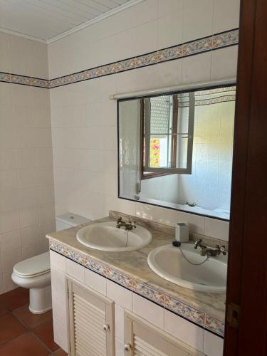 a bathroom with a sink and a toilet and a mirror at Chalet con piscina in Tui