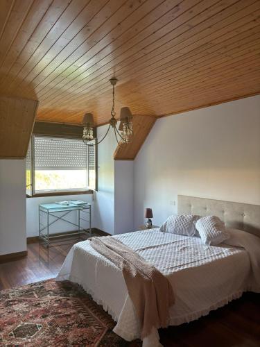 a bedroom with a large bed with a wooden ceiling at Chalet con piscina in Tui