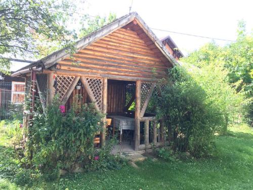 a wooden gazebo with a grill in the grass at Casa Matei in Poarta