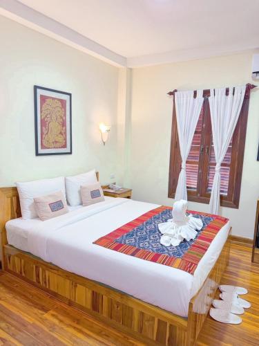 a bedroom with a large bed in a room at Luang Phasouk Hotel in Luang Prabang