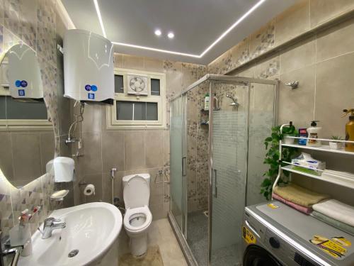 a bathroom with a sink toilet and a shower at شقه فندقيه لك بالكامل غرفتين في كمباوند راقي بالشيخ زايد in Sheikh Zayed