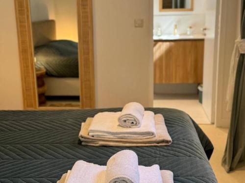 a bedroom with a bed with towels and a mirror at Villa de luxe avec piscine au cœur de Hossegor, proche golf, plage et lac - FR-1-791-9 in Soorts-Hossegor