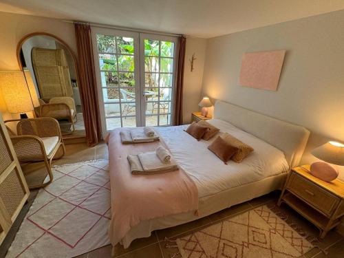 a bedroom with a large bed with towels on it at Villa de luxe avec piscine au cœur de Hossegor, proche golf, plage et lac - FR-1-791-9 in Soorts-Hossegor