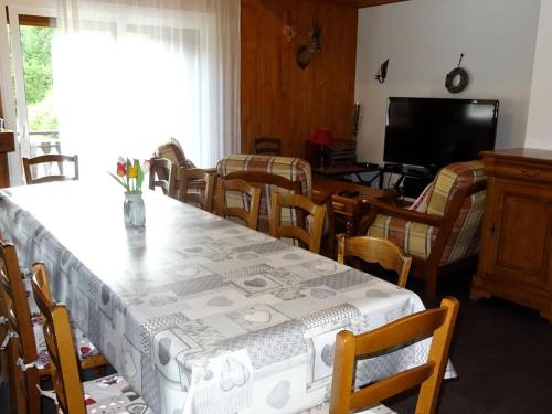 une salle à manger avec une table, des chaises et une télévision dans l'établissement Les Gets : Duplex 6 pièces pour 12 pers., wifi, garage, proche pistes – Draps et serviettes inclus l’hiver - FR-1-802-9, aux Gets