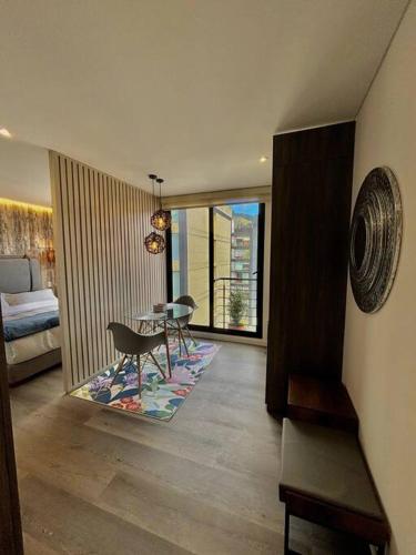 un salon avec une table et des chaises et une chambre dans l'établissement Luxury loft en el Parque Virrey, à Bogotá