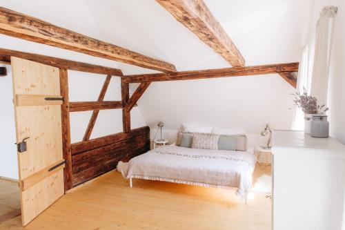 a bedroom with a white bed and wooden beams at Palitz No 17 - venkovské stavení in Lipová