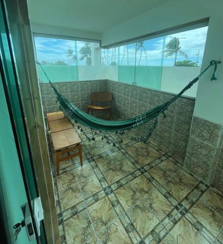 a hammock in a room with a tiled floor at Casamar Pousada in Paulista