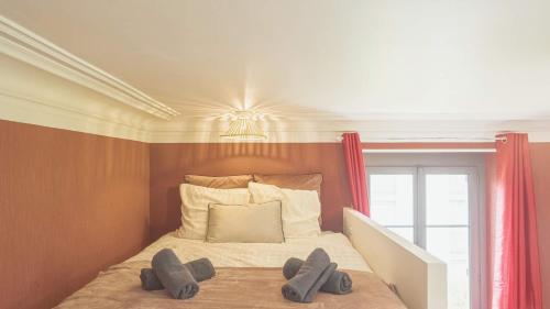Un dormitorio con una cama con dos pantuflas encima. en BonAppart 14 - Charme Napoléonien & Confort, en Troyes