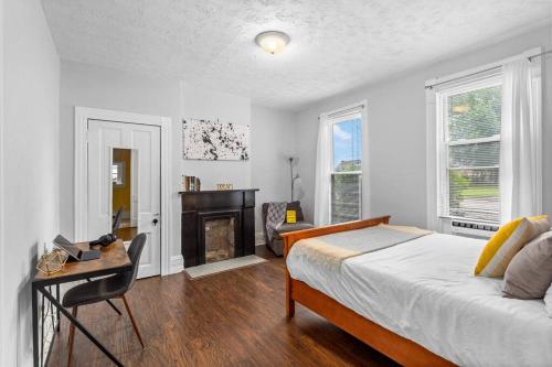 a bedroom with a bed and a desk and a fireplace at Stylish King Bed, 2BDRM, 1 Mile to DTWN, Game Room in Cleveland