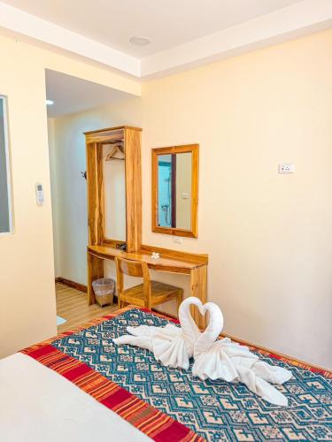 a bedroom with a bed with a swan decoration on it at Luang Phasouk Hotel in Luang Prabang