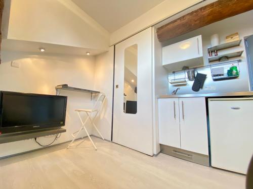 - un salon avec une télévision et un réfrigérateur dans l'établissement Mini Studio - Le Chabaud - Cannes centre, à Cannes
