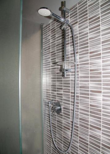 a shower with a shower head in a bathroom at Hotel Victoria in Varedo