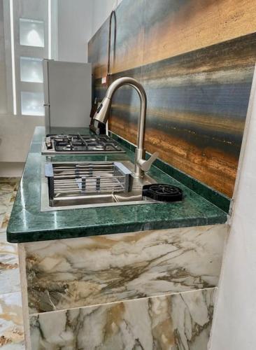 a kitchen counter with a sink and a sink at Appartement Les Vagues Bleues in Monastir