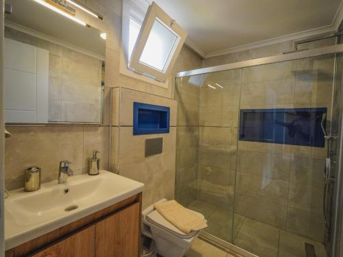 a bathroom with a shower and a sink and a toilet at Villa Pelit - 4 Yatak Odalı Saunalı Havuzlu Villa in Fethiye